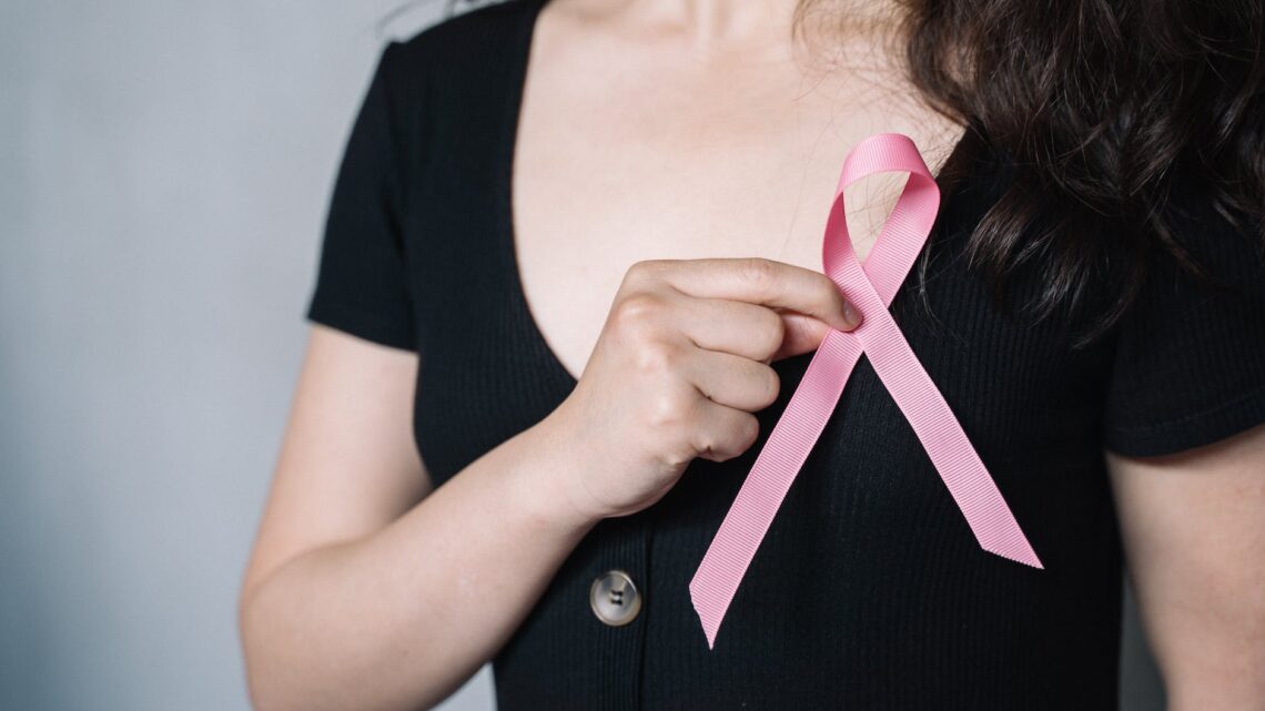 woman holding pink ribbon