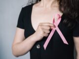 woman holding pink ribbon