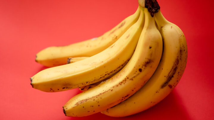 Yellow banana fruit on red surface