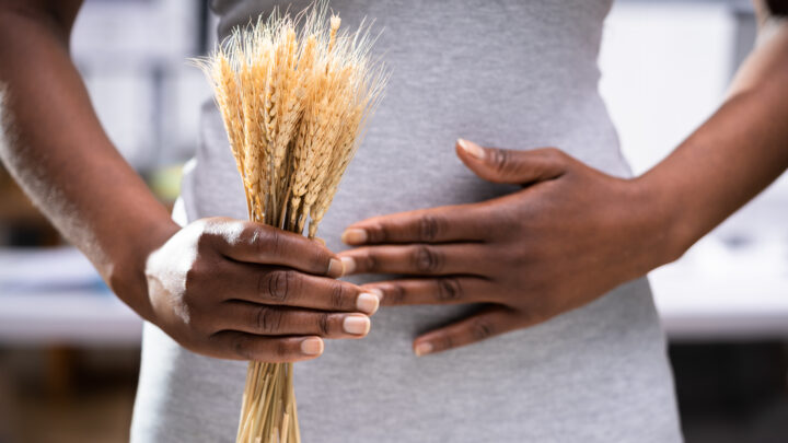 Celiac Disease And Gluten Intolerance. Women Holding Spikelet Of Wheat