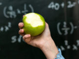 Sweet lesson: Girl with an apple - a symbol of health and education against the backdrop of a school blackboard.