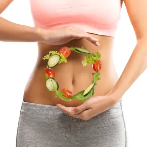 Fit, young woman holding a circle made out of vegetables over her abdomen